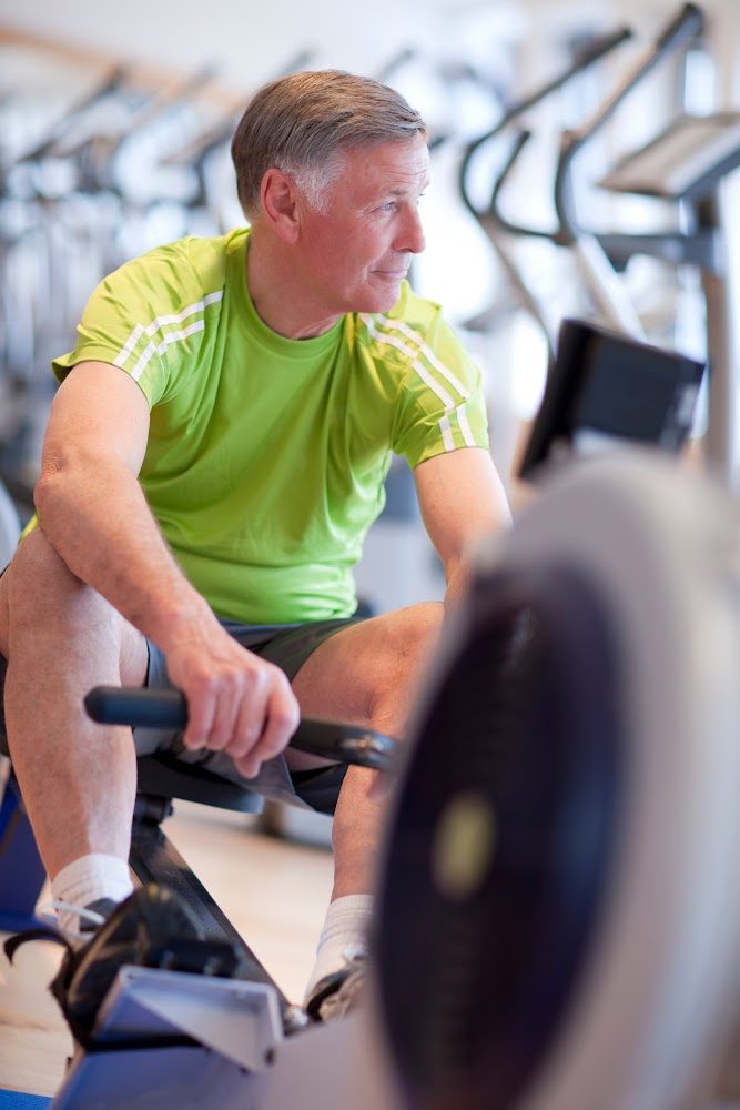 Man sitting on fitness equipment Man sitting on fitness equipment